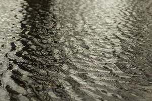 vågor på vatten. vind på yta av vatten. reflexion i pöl. foto