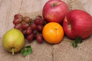 frukt med vitamin c den där är välgörande till de kropp. plats på säckväv - orange, druva, äpple, guava foto