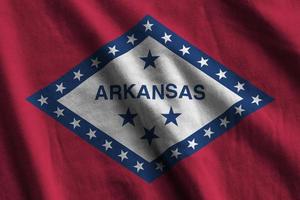 Arkansas oss stat flagga med stor veck vinka stänga upp under de studio ljus inomhus. de officiell symboler och färger i baner foto