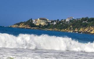 ytterst enorm stor surfare vågor på strand puerto escondido Mexiko. foto