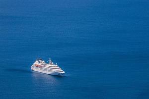 skön landskap med hav se. kryssning fartyg i blå bukt stänga till fira stad. underbar resa landskap. resa och turism transport bakgrund i santorini grekland foto