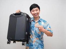 porträtt asiatisk man strand skjorta leende punkt finger på bagage isolerat foto