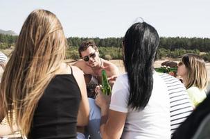 sommar, högtider, semester, musik, Lycklig människor begrepp - grupp av vänner med gitarr har roligt på de strand foto