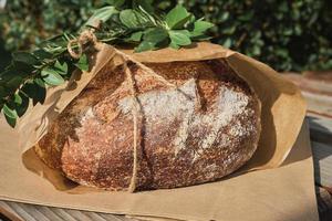 närbild av traditionell runda bröd på hantverk papper paket dekorerad med gren på jul marknadsföra. foto