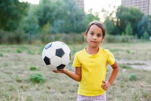 söt ung flicka i enhetlig spelar i organiserad ungdom liga fotboll spel foto