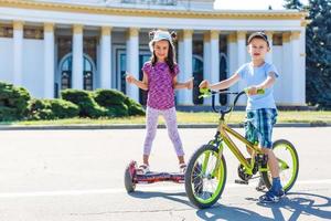 flicka på en cykel och en pojke på en gyroskop är ridning tillsammans foto