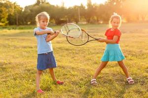 två liten flickor med tennis racketar foto
