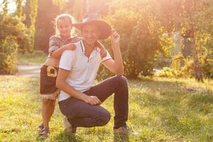 pappa och dotter klädd i cowboy stil ha roligt på de bruka foto