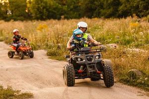 liten pojke med instruktör på en quad cykel foto