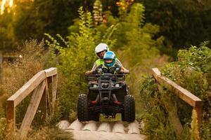 liten pojke med instruktör på en quad cykel foto