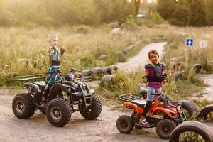 pojke flicka rider på elektrisk atv fyrhjuling. foto