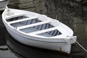 vit förtöjd båt på en flod är hav med rep och reflexion. selektiv fokus foto