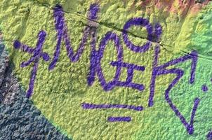 fragment av graffiti ritningar. de gammal vägg dekorerad med måla fläckar i de stil av gata konst kultur. färgad bakgrund textur i värma toner foto