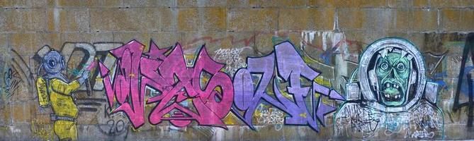 fragment av graffiti ritningar. de gammal vägg dekorerad med måla fläckar i de stil av gata konst kultur. skrämmande dykning dykare foto