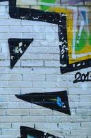 fragment av graffiti ritningar. de gammal vägg dekorerad med måla fläckar i de stil av gata konst kultur. färgad bakgrund textur foto