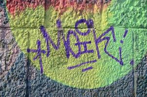 fragment av graffiti ritningar. de gammal vägg dekorerad med måla fläckar i de stil av gata konst kultur. färgad bakgrund textur i värma toner foto