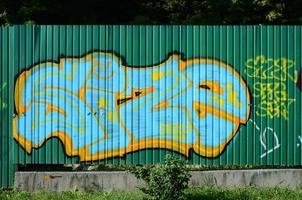 fragment av graffiti ritningar. de gammal vägg dekorerad med måla fläckar i de stil av gata konst kultur. färgad bakgrund textur i grön toner foto