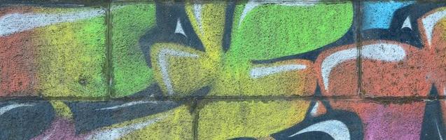 fragment av graffiti ritningar. de gammal vägg dekorerad med måla fläckar i de stil av gata konst kultur. flerfärgad bakgrund textur foto