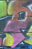 fragment av graffiti ritningar. de gammal vägg dekorerad med måla fläckar i de stil av gata konst kultur. flerfärgad bakgrund textur foto