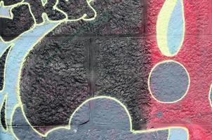 fragment av graffiti ritningar. de gammal vägg dekorerad med måla fläckar i de stil av gata konst kultur. flerfärgad bakgrund textur foto