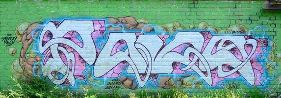 fragment av graffiti ritningar. de gammal vägg dekorerad med måla fläckar i de stil av gata konst kultur. färgad bakgrund textur i grön toner foto