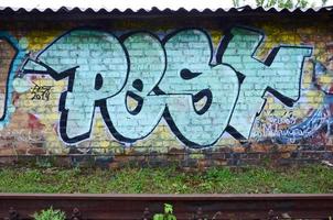 full och genomfört graffiti konstverk. de gammal vägg dekorerad med måla fläckar i de stil av gata konst kultur. färgad bakgrund textur foto