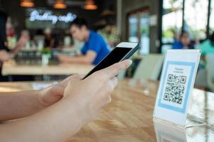 kvinna använda sig av smartphone till skanna qr koda till betala i Kafé restaurang med en digital betalning utan kontanter. välja meny och beställa ackumulera rabatt. e plånbok, teknologi, betala uppkopplad, kreditera kort, Bank app foto