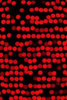 ofokuserad abstrakt röd bokeh på svart bakgrund. defocused och suddig många runda ljus foto