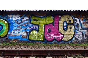 full och genomfört graffiti konstverk. de gammal vägg dekorerad med måla fläckar i de stil av gata konst kultur. färgad bakgrund textur foto