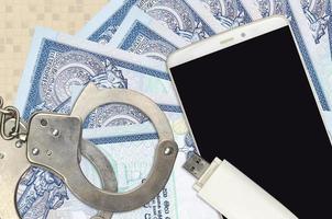50 sri lankanska rupier räkningar och smartphone med polis handklovar. begrepp av hackare nätfiske attacker, olaglig lurendrejeri eller skadliga program mjuk distribution foto