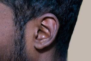 mänsklig öra - stänga upp av en mannens öra dess kropp del hjälper till höra ljud vågor. foto