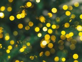 suddig dekorerad jul träd, gul bokeh av krans ljus, ny år texturerad bakgrund foto
