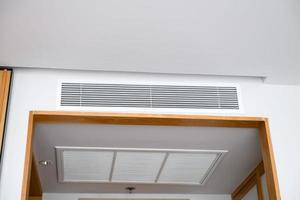 tak monterad kassett typ luft balsam och modern lampa ljus på vit tak. kanal luft balsam för Hem eller kontor foto
