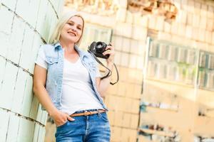 porträtt av en Söt ung turist tar fotografier med årgång retro kamera foto