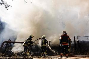 brandmän i handling, brand slangar foto