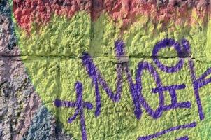 fragment av graffiti ritningar. de gammal vägg dekorerad med måla fläckar i de stil av gata konst kultur. färgad bakgrund textur i värma toner foto