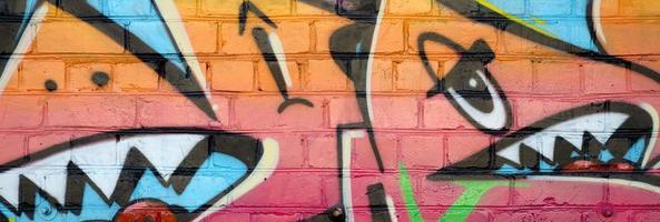 abstrakt färgrik fragment av graffiti målningar på gammal tegel vägg. gata konst sammansättning med delar av oskriven brev och flerfärgad fläckar. subkulturella bakgrund textur foto