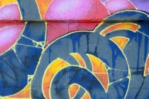 fragment av graffiti ritningar. de gammal vägg dekorerad med måla fläckar i de stil av gata konst kultur. flerfärgad bakgrund textur foto