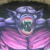 fragment av graffiti ritningar. de gammal vägg dekorerad med måla fläckar i de stil av gata konst kultur. lila skrämmande monster foto