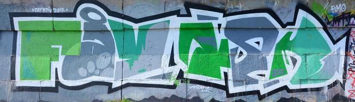 fragment av graffiti ritningar. de gammal vägg dekorerad med måla fläckar i de stil av gata konst kultur. färgad bakgrund textur i grön toner foto