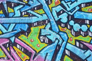 fragment av graffiti ritningar. de gammal vägg dekorerad med måla fläckar i de stil av gata konst kultur. färgad bakgrund textur i kall toner foto