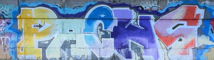 fragment av graffiti ritningar. de gammal vägg dekorerad med måla fläckar i de stil av gata konst kultur. flerfärgad bakgrund textur foto