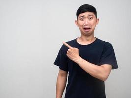 asiatisk ung man känner förvånad och förvirrad gest punkt finger isolerat foto