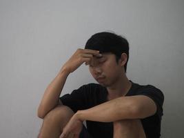 asiatisk man stänga hans ansikte känner hopplös och deprimerad foto