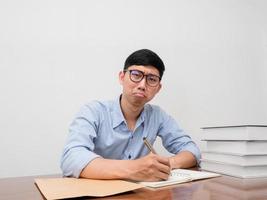 asiatisk affärsman ha på sig glasögon sitta på arbetssätt tabell känner uttråkad och försökte foto