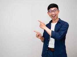 glad asiatisk man ha på sig glasögon gest punkt finger isolerat foto