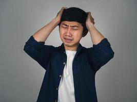 deprimerad asiatisk man huvudvärk och gråt handla om hans liv foto