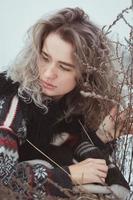 stänga upp omtänksam kvinna i Tröja på vinter- äng porträtt bild foto