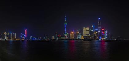 panorama- bild av skyskrapor av pudong distrikt från de bund i shanghai på natt i vinter- foto