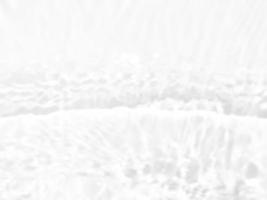 defokusering suddig transparent vit färgad klar lugna vatten yta textur med stänk och bubblor. trendig abstrakt natur bakgrund. vatten vågor i solljus med kopia Plats. vit vatten glans konst. foto